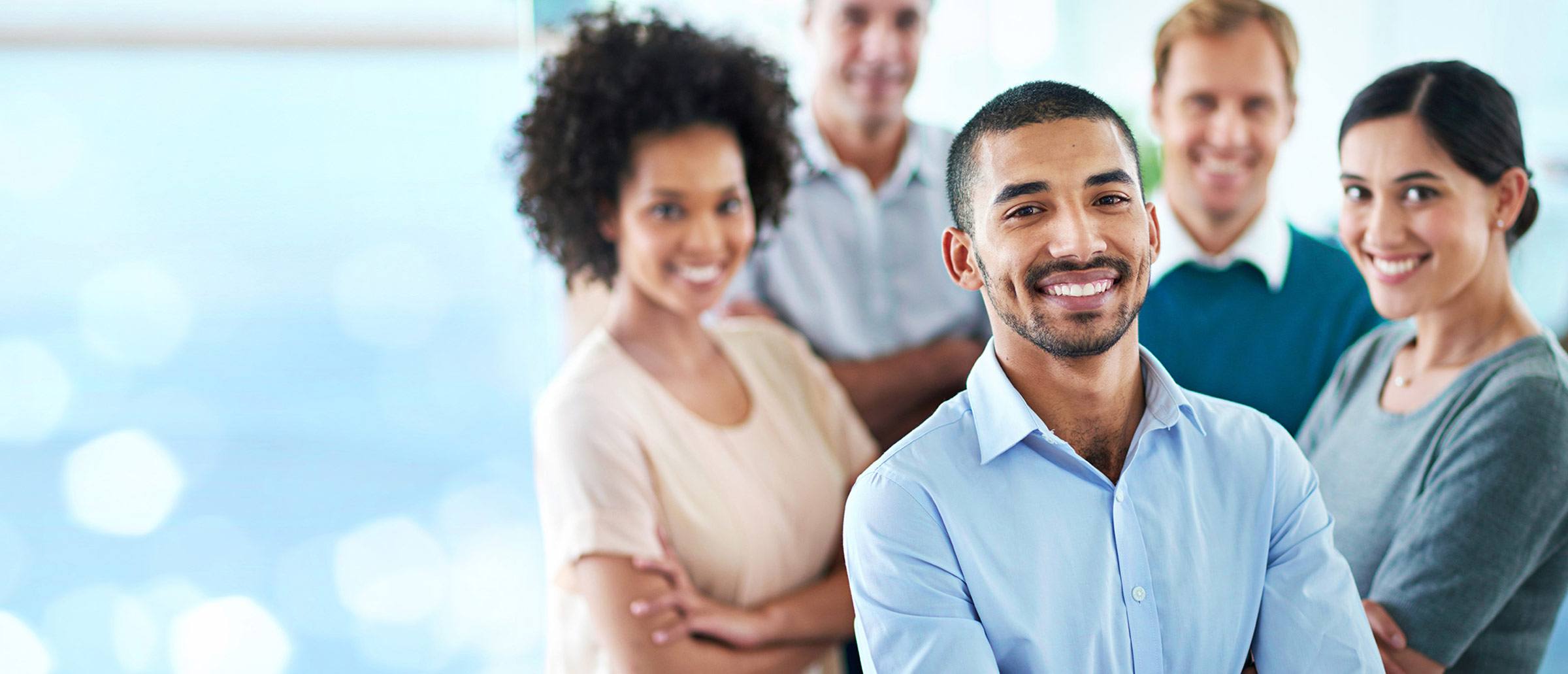 Group of diverse young professionals with folded arms smiling